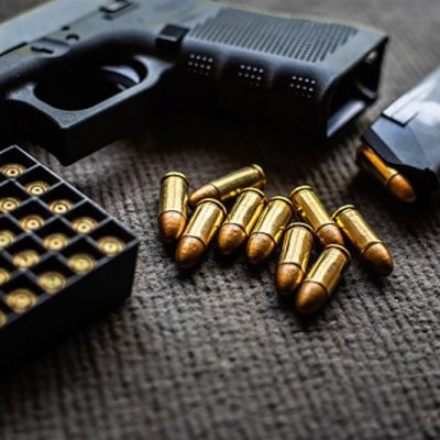 bullets and gun on black velvet desk