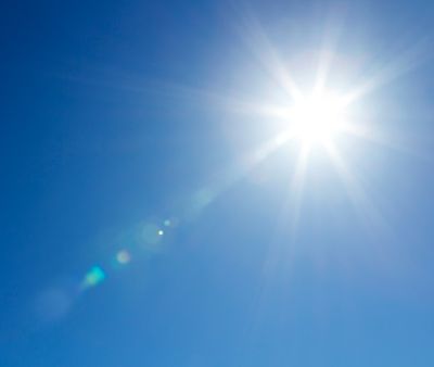 Sun shining at clear sky with real lens flare and copy space