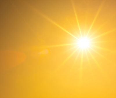 Summer background, orange sky with glowing sun