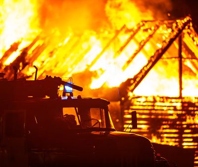 Arson or nature disaster - burning fire flame on wooden house rooft